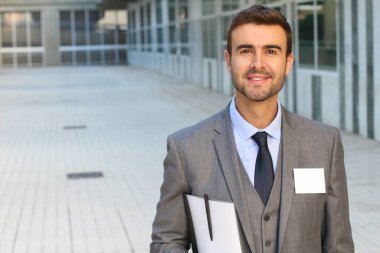 Sokakta gri takım elbiseli yakışıklı genç işadamının yakın plan portresi.