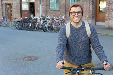 Şehirde bisiklet süren şık bir etnik adam.