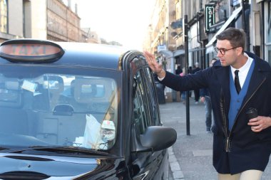 Sokakta taksiye binen yakışıklı genç adamın yakın plan portresi.