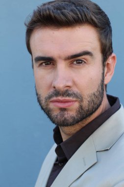 Duvarın önündeki yakışıklı sakallı adamın yakın plan portresi.