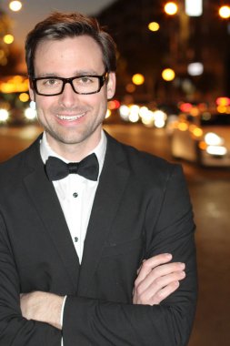 smokinli ve papyonlu yakışıklı bir delikanlının akşam vakti şehir caddesinde yakın plan fotoğrafı.