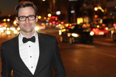 smokinli ve papyonlu yakışıklı bir delikanlının akşam vakti şehir caddesinde yakın plan fotoğrafı.