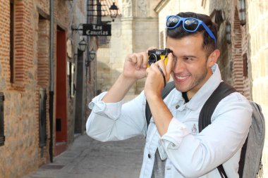 Klasik kamerayla fotoğraf çekmek için yaratıcılığını kullanan bir adam.