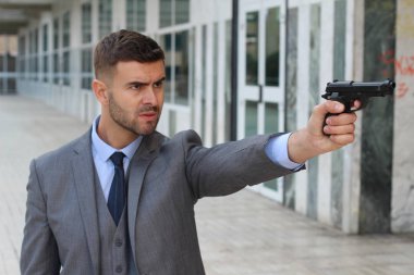 Takım elbiseli yakışıklı ve sokakta silahlı genç bir işadamının yakın plan fotoğrafı.