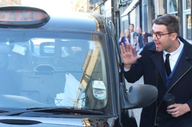 Sokakta taksiye binen yakışıklı genç adamın yakın plan portresi.