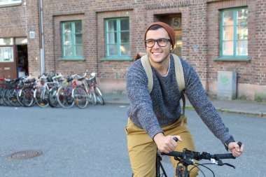 Şehirde bisiklet süren şık bir etnik adam.