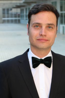 Siyah takım elbiseli, papyonlu yakışıklı bir gencin yakın plan portresi.