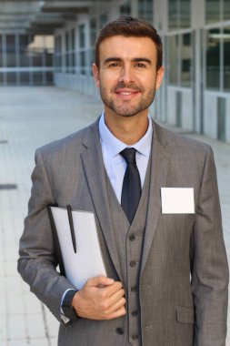 Sokakta gri takım elbiseli yakışıklı genç işadamının yakın plan portresi.