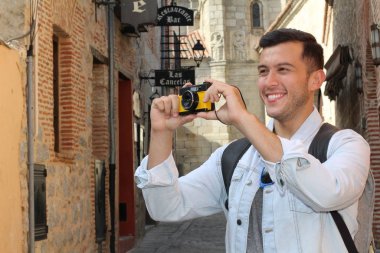 Klasik kamerayla fotoğraf çekmek için yaratıcılığını kullanan bir adam.