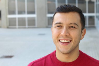 Caddedeki kırmızı kazaklı yakışıklı genç adamın yakın plan portresi.