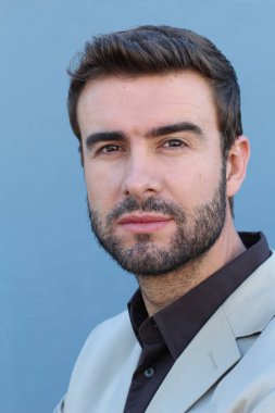 Duvarın önündeki yakışıklı sakallı adamın yakın plan portresi.