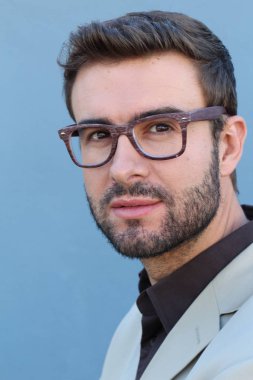 Duvarın önündeki yakışıklı sakallı adamın yakın plan portresi.