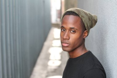 Sokakta siyah tişörtlü yakışıklı Afro-Amerikan adamın yakın plan portresi.