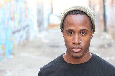 Siyah tişörtlü ve şapkalı yakışıklı Afro-Amerikan adamın yakın plan portresi.