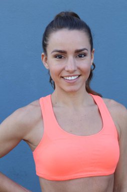 Mavi arka planda kaslı vücutlu kadın fitness portresi 