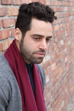 Duvarın önündeki yakışıklı genç adamın yakın plan portresi.