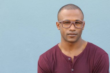 Mavi duvarın önündeki yakışıklı Afro-Amerikan 'ın yakın plan portresi.