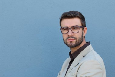 Duvarın önündeki yakışıklı sakallı adamın yakın plan portresi.