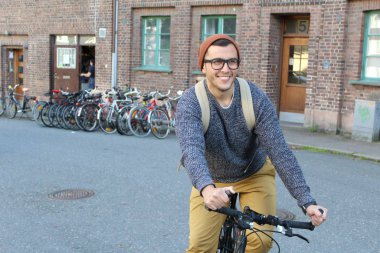 Şehirde bisiklet süren şık bir etnik adam.