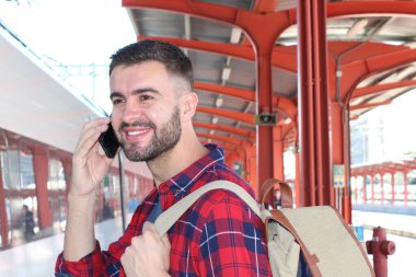 Tren istasyonunda sırt çantalı yakışıklı bir gencin yakın plan portresi.