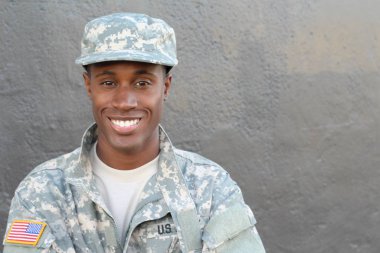 Gri duvarın önündeki yakışıklı Afro-Amerikan askerinin yakın plan portresi.