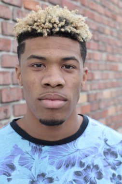 Duvarın önündeki yakışıklı genç adamın yakın plan portresi.