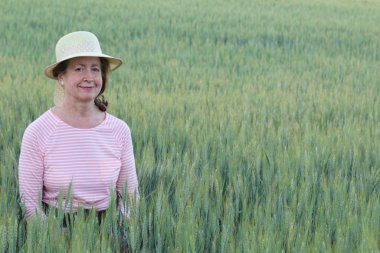 Buğday tarlalarında olgun doğal bir kadın.