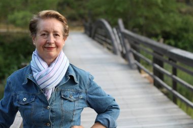 parkta gülümseyen güzel yaşlı bir kadın portresi