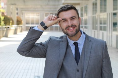 Sokakta gri takım elbiseli yakışıklı genç işadamının yakın plan portresi.