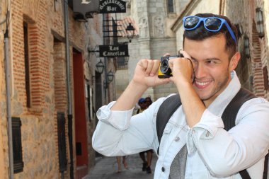 Klasik kamerayla fotoğraf çekmek için yaratıcılığını kullanan bir adam.