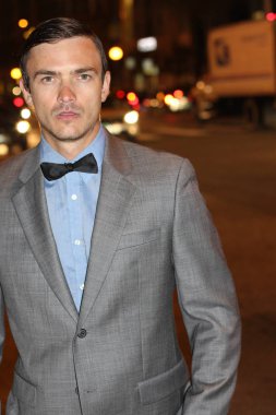 Geceleri sokakta papyonlu yakışıklı genç bir adamın yakın plan portresi.