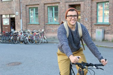 Şehirde bisiklet süren şık bir etnik adam.