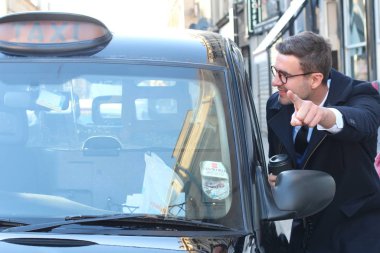 Sokakta taksiye binen yakışıklı genç adamın yakın plan portresi.