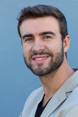 Duvarın önündeki yakışıklı sakallı adamın yakın plan portresi.