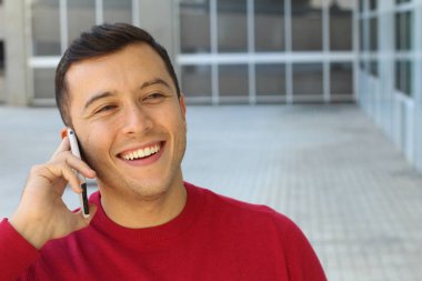 close-up portrait of handsome young man talking by phone on street