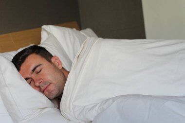 Etnik adam rahat bir yatakta derin bir uyku çekti.