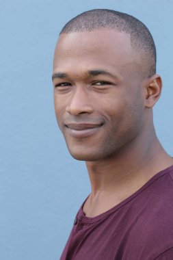 Mavi duvarın önündeki yakışıklı Afro-Amerikan 'ın yakın plan portresi.