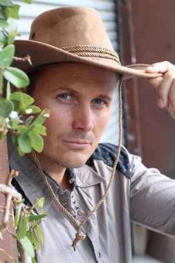 Kovboy şapkalı yakışıklı genç adamın yakın plan portresi.