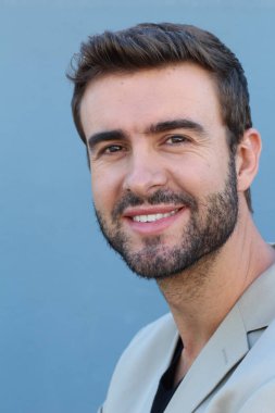 Duvarın önündeki yakışıklı sakallı adamın yakın plan portresi.