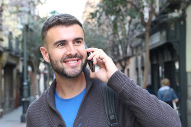 Avrupa 'nın caddesinde günlük kıyafetlerle konuşan yakışıklı genç adamın yakın plan portresi.