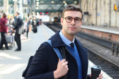 İş adamı retro tren istasyonunda yürüyor