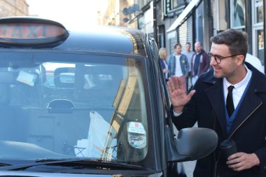 Sokakta taksiye binen yakışıklı genç adamın yakın plan portresi.