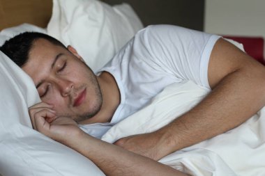 Etnik adam rahat bir yatakta derin bir uyku çekti.