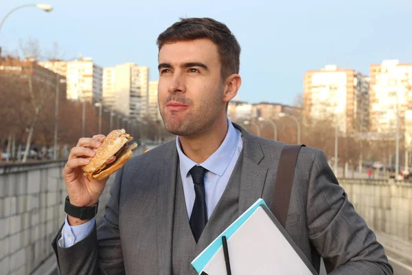 Közeli Kép Jóképű Fiatal Üzletemberről Öltönyben Hamburgert Eszik Utcán — Stock Fotó