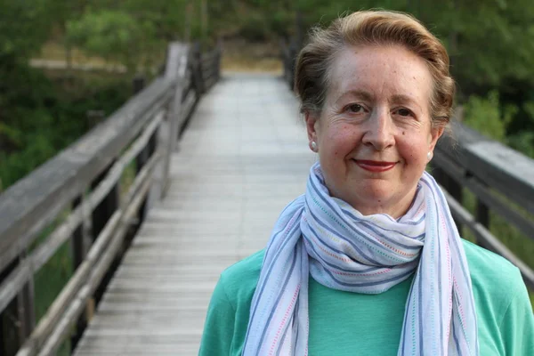 Portrait of a beautiful older woman smiling in the park