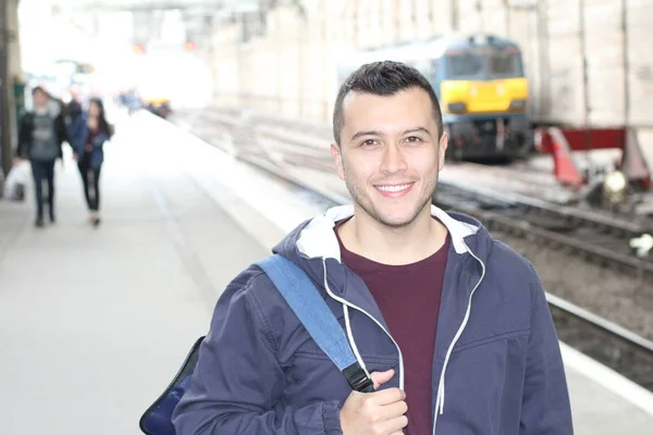 Cute ethnic young man in retro train station