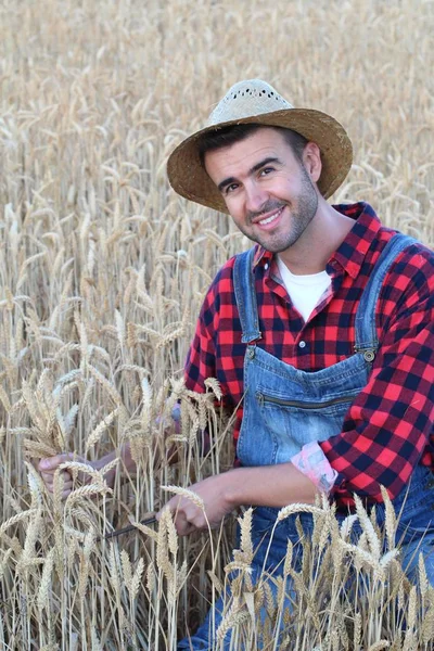 農家の服を着たハンサムな若い男と自然の上で麦畑の上に麦畑の帽子のクローズアップ肖像画 — ストック写真
