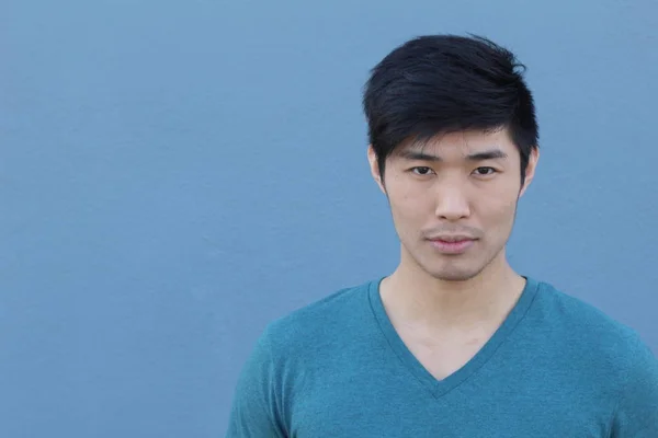 青い壁の前に立つハンサムなアジア系の男の肖像画 — ストック写真