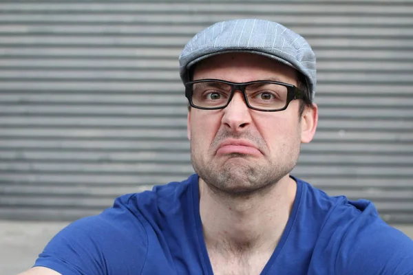 close-up shot of handsome young man in casual clothes in front of grey wall