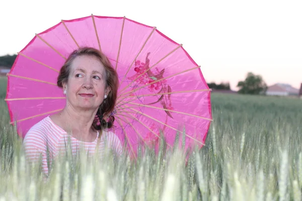 Volwassen Vrouw Met Een Roze Paraplu Tijdens Zonnige Dag — Stockfoto